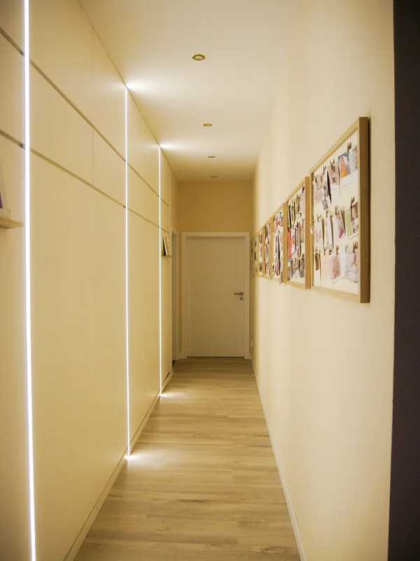 Langer Flur mit indirektem Licht und Bilderleiste