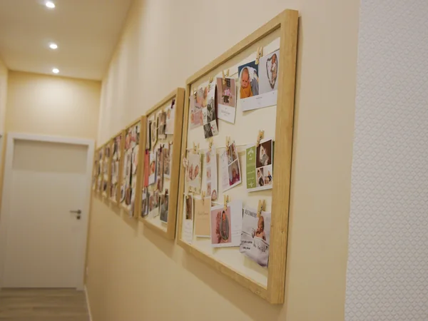 Fotowand im Flur mit Bildern begleiteter Familien